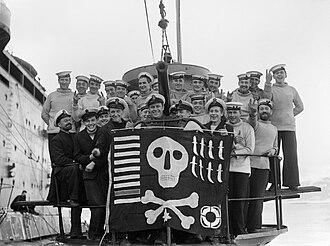 The personnel of the British submarine HMS Utmost showing off their Jolly Roger in February 1942. The markings on the flag indicate the boat's achievements: nine ships torpedoed (including one warship), eight 'cloak and dagger' operations, one target destroyed by gunfire, and one at-sea rescue. british navy skull and bones emblem